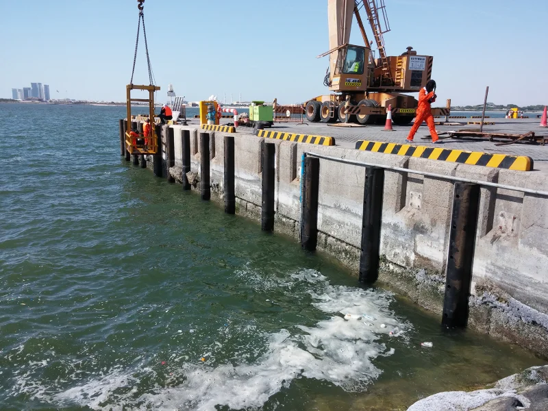 D-section rubber fenders bolted along a pontoon edge with a vessel alongside