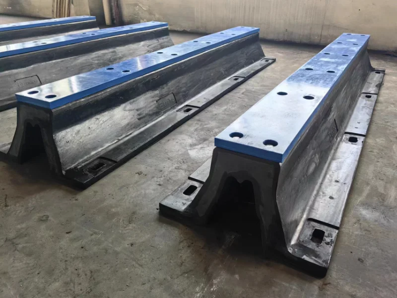 Cutaway of a V-shaped arch rubber fender with base flanges and bolt holes