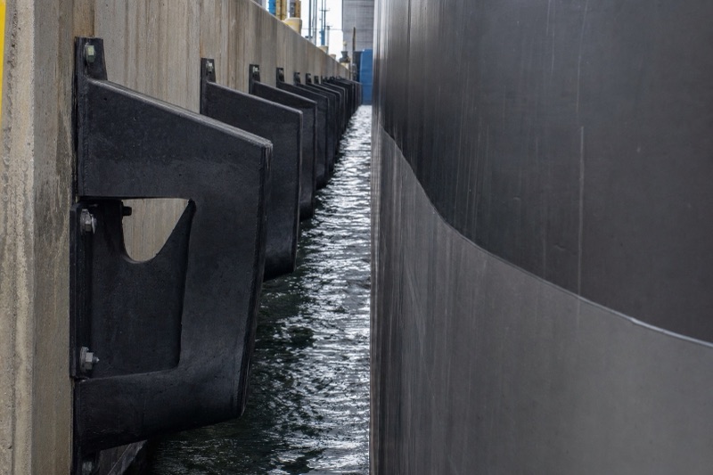 V-shaped arch rubber fenders bolted along a quay wall with a ship alongside