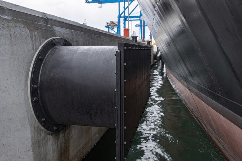Super cell rubber fender with a front panel bolted to a quay wall with a ship alongside